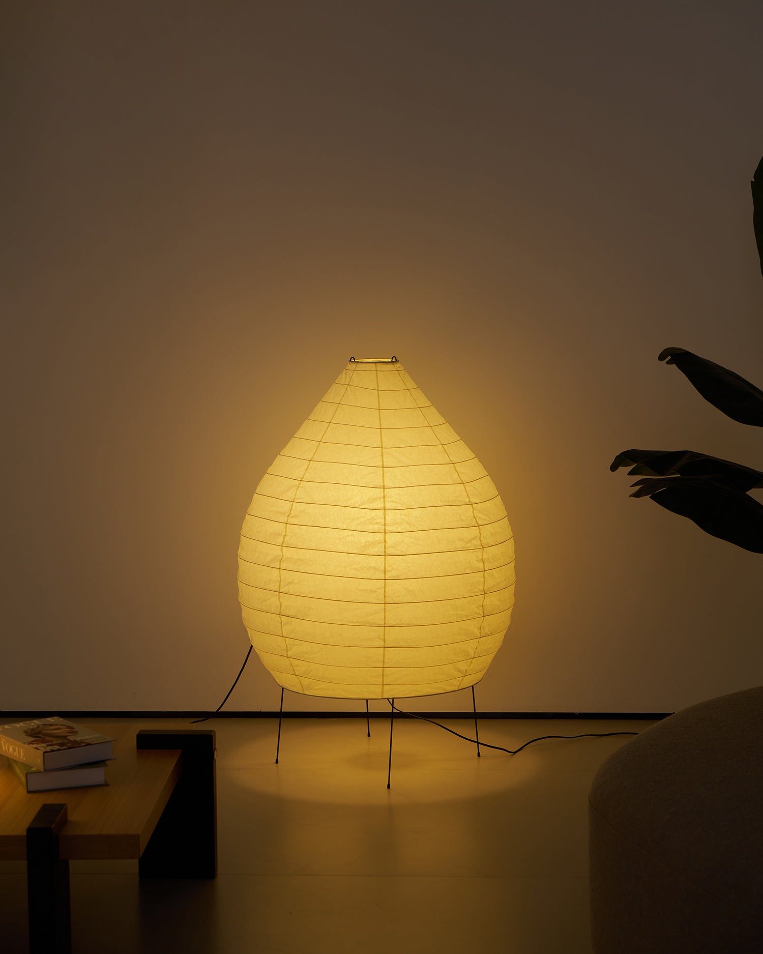 Akari 23N floor lamp with warm amber glowing washi paper shade in residential interior at night