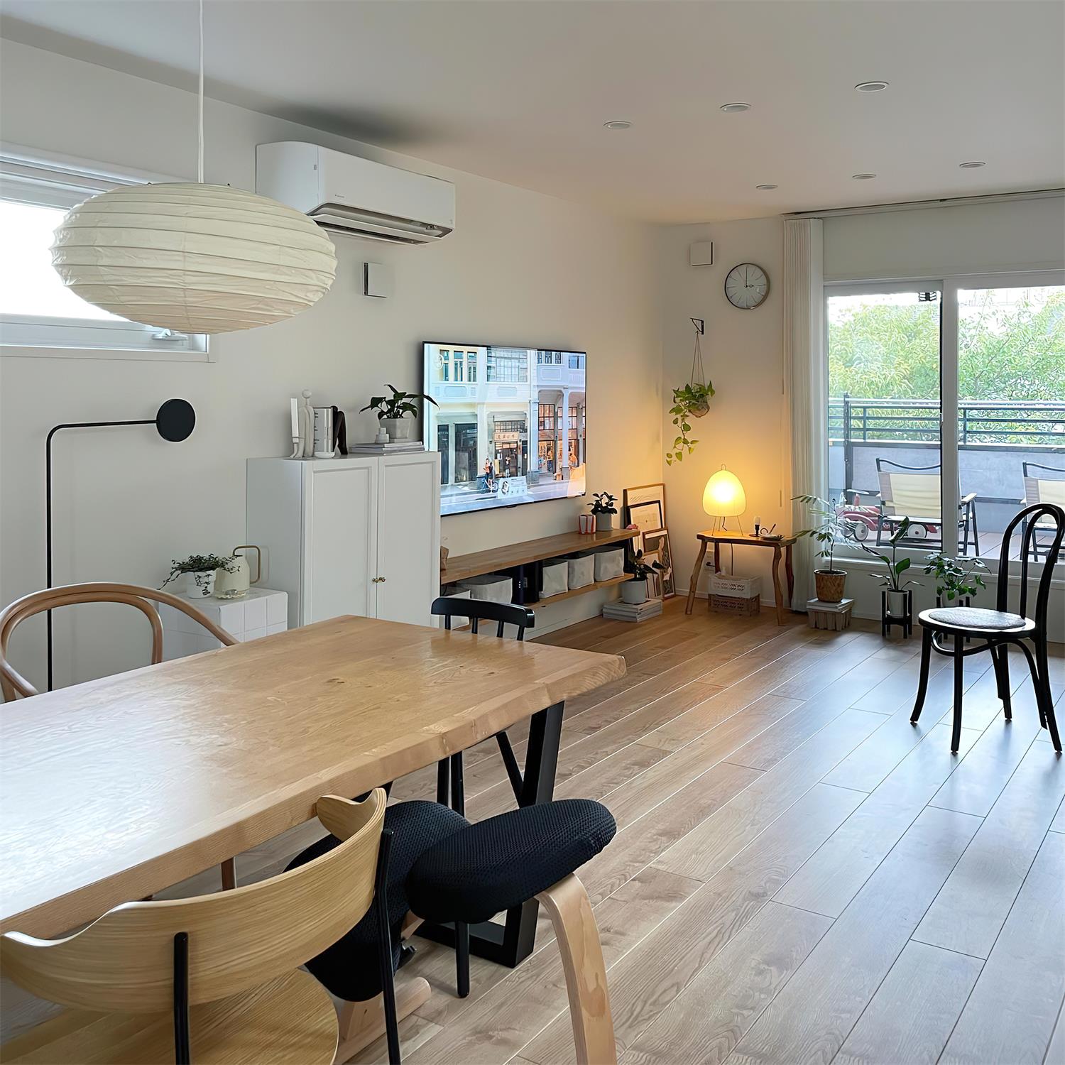 Akari 50EN beige rice paper pendant lamp in modern open-plan dining-living space with Nordic minimalist interior design