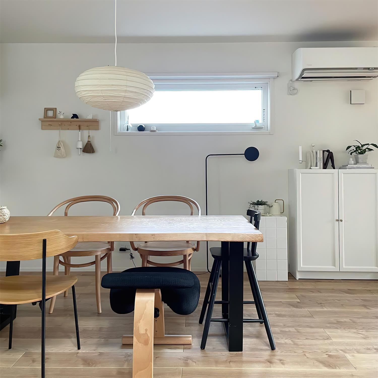 Akari 50EN washi paper pendant lamp in minimalist dining room with clean wabi-sabi style, neutral-toned interior aesthetic