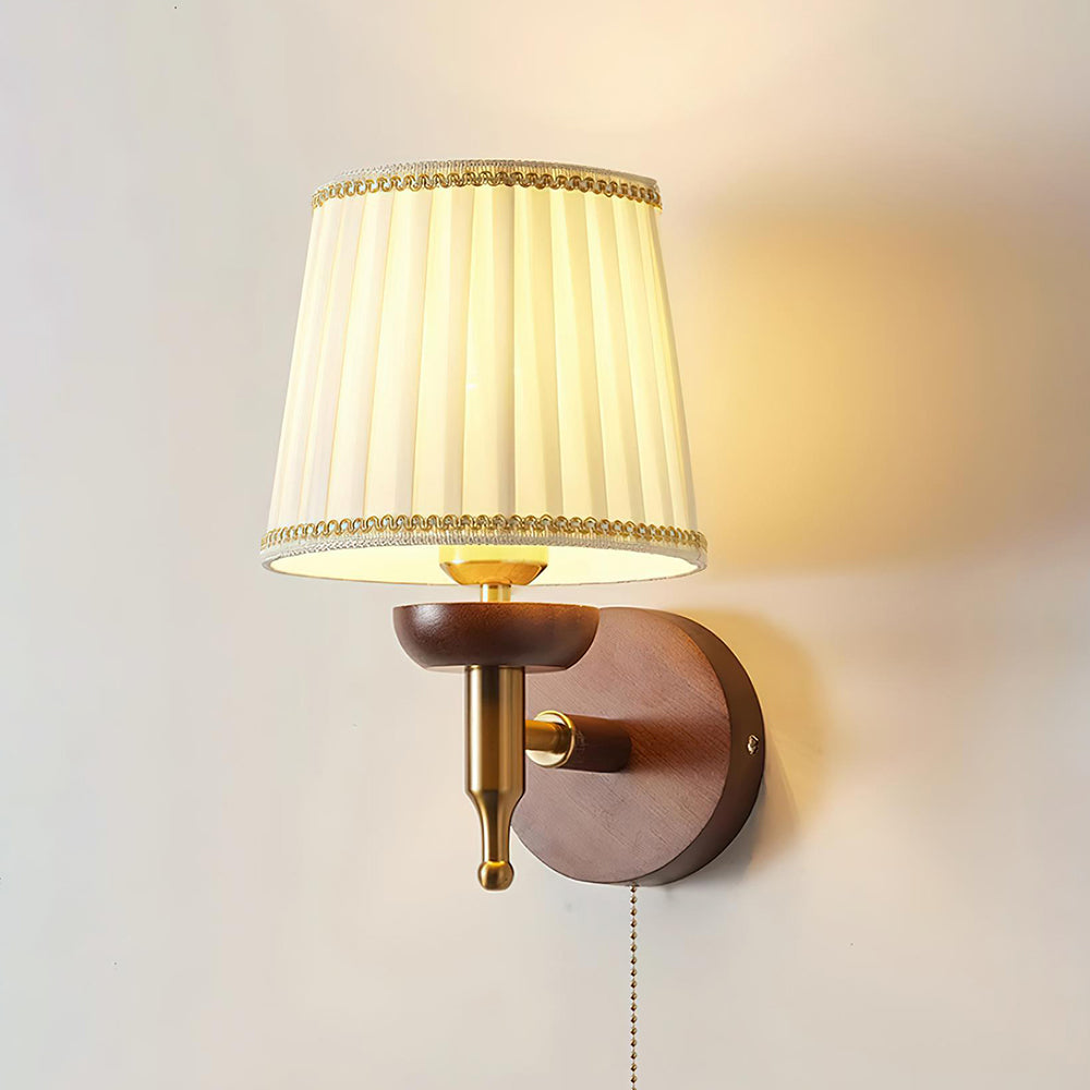 Blixen wall sconce close-up detail showing brass hardware and decorative gold trim on pleated shade