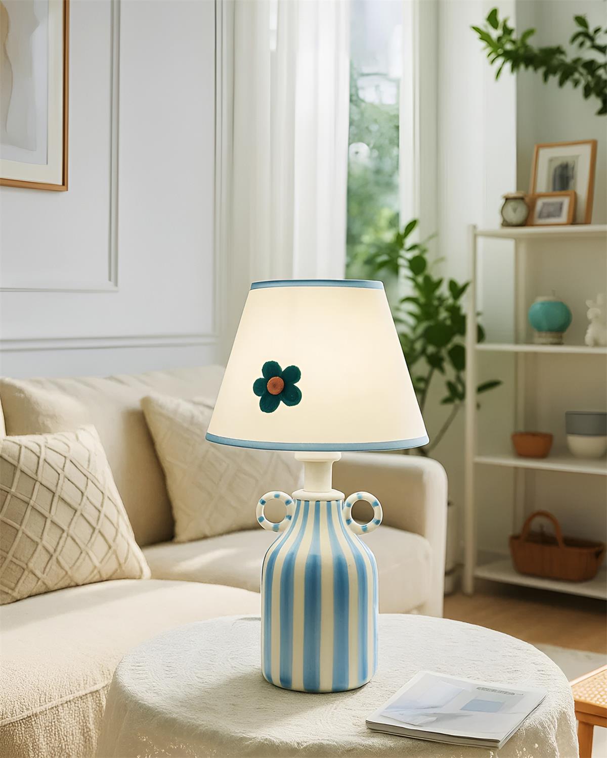 Artisanal ceramic striped table lamp displayed on living room coffee table with modern interior design
