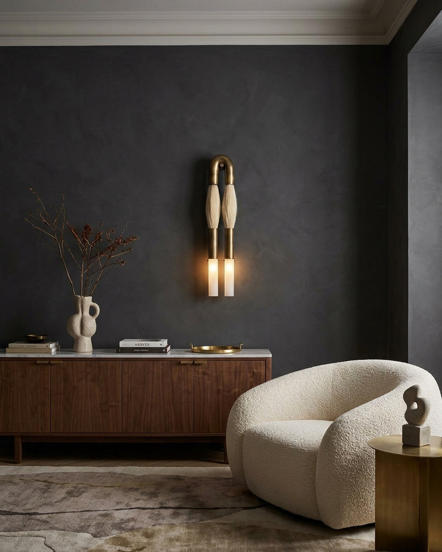 Branwick modern wall sconce mounted on dark charcoal wall in minimalist lounge near wooden console table with curated accessories