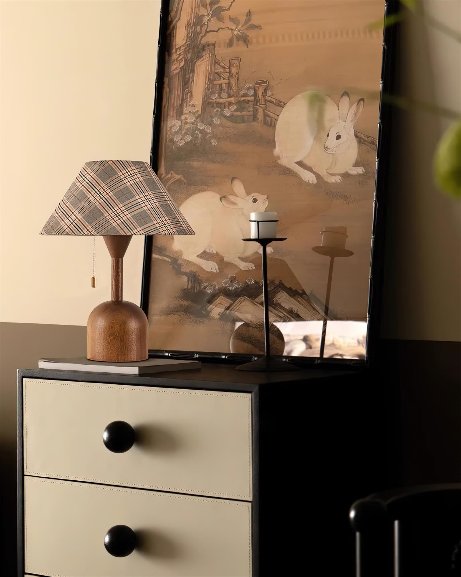 Rustic cabin table lamp with plaid shade on vintage drawer cabinet with artwork