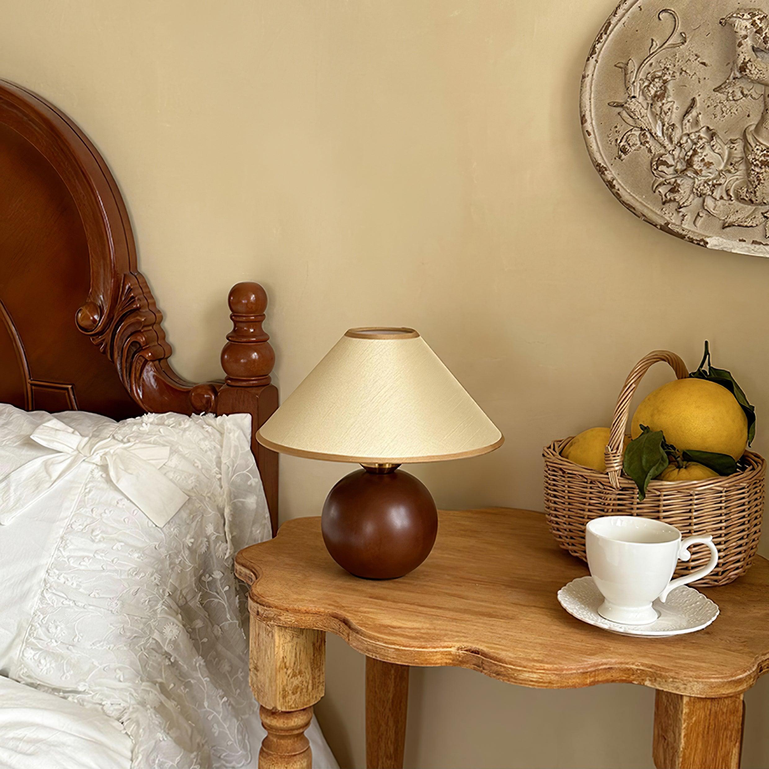 Natural wood table lamp with fabric shade in home environment, warm ambient glow