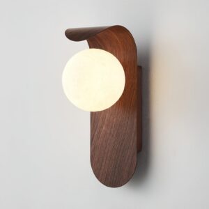 Modern plug-in wall sconce side profile showing curved backplate and spherical lamp shade