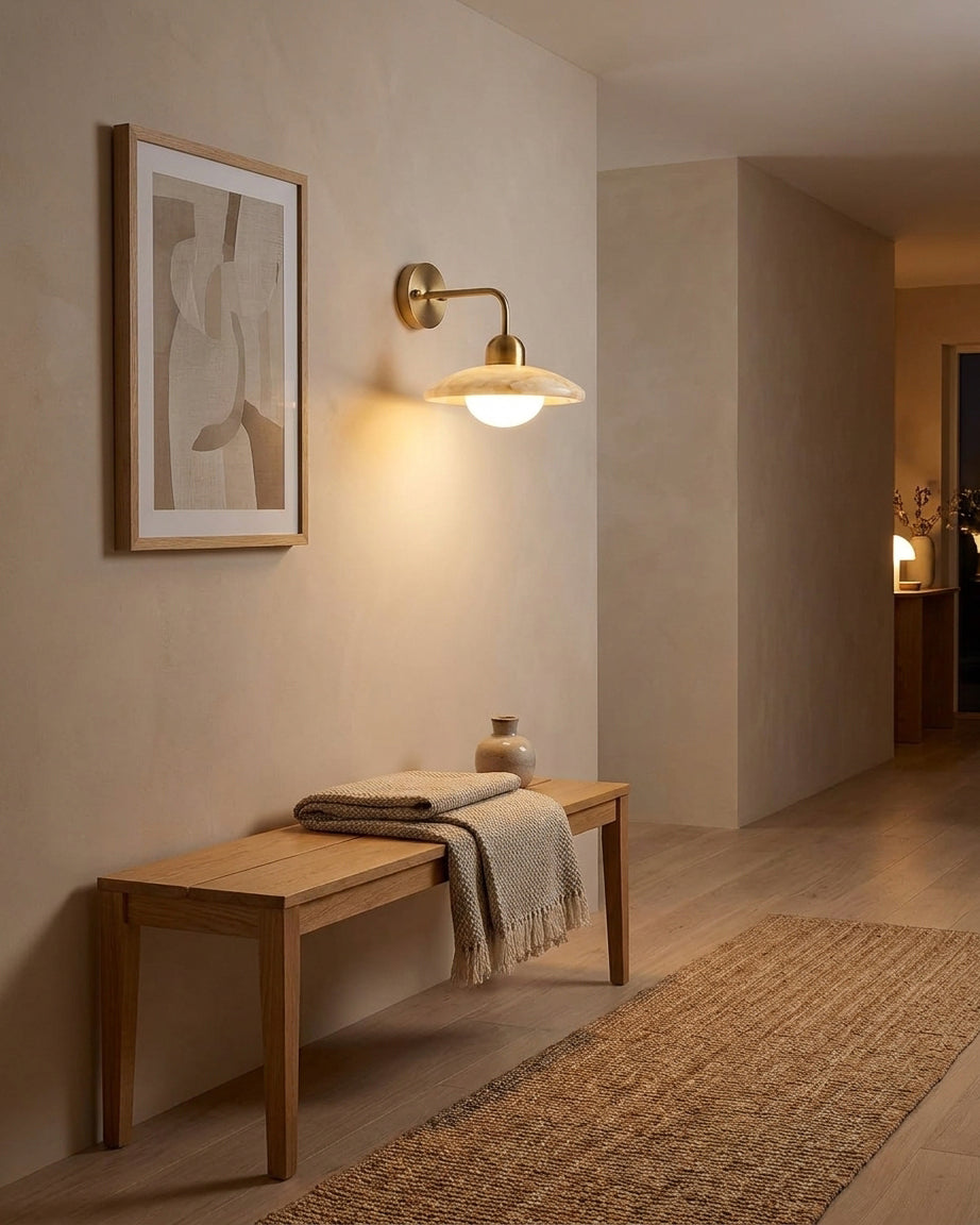 Carolia alabaster wall sconce mounted in minimalist entryway above wooden bench mid-century modern interior