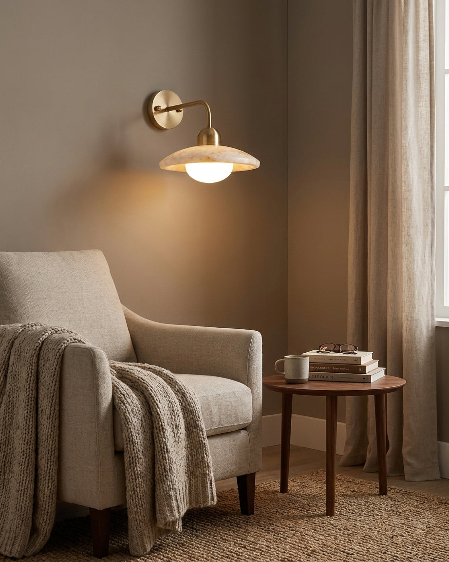Carolia alabaster wall sconce above fabric armchair in living room seating nook with warm accent lighting