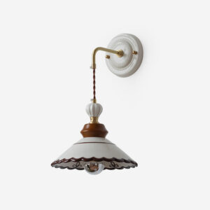 Celine scalloped ceramic wall sconce with brown edging and brass hardware, studio front view
