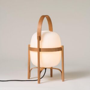 Modern portable lantern lamp with illuminated frosted glass shade and power cord visible