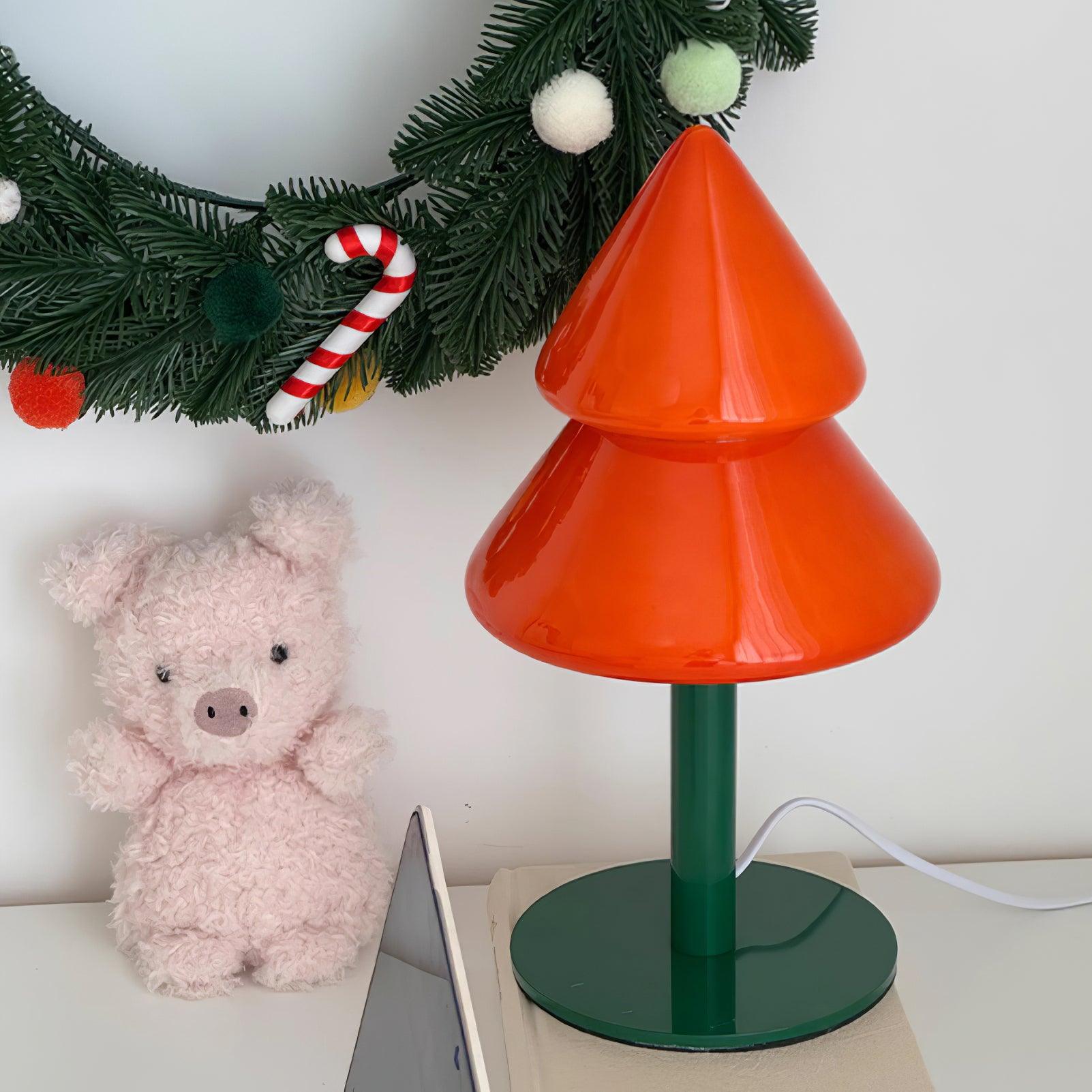 Contemporary Christmas tree table lamp styled with festive wreath and holiday decorations on home desktop