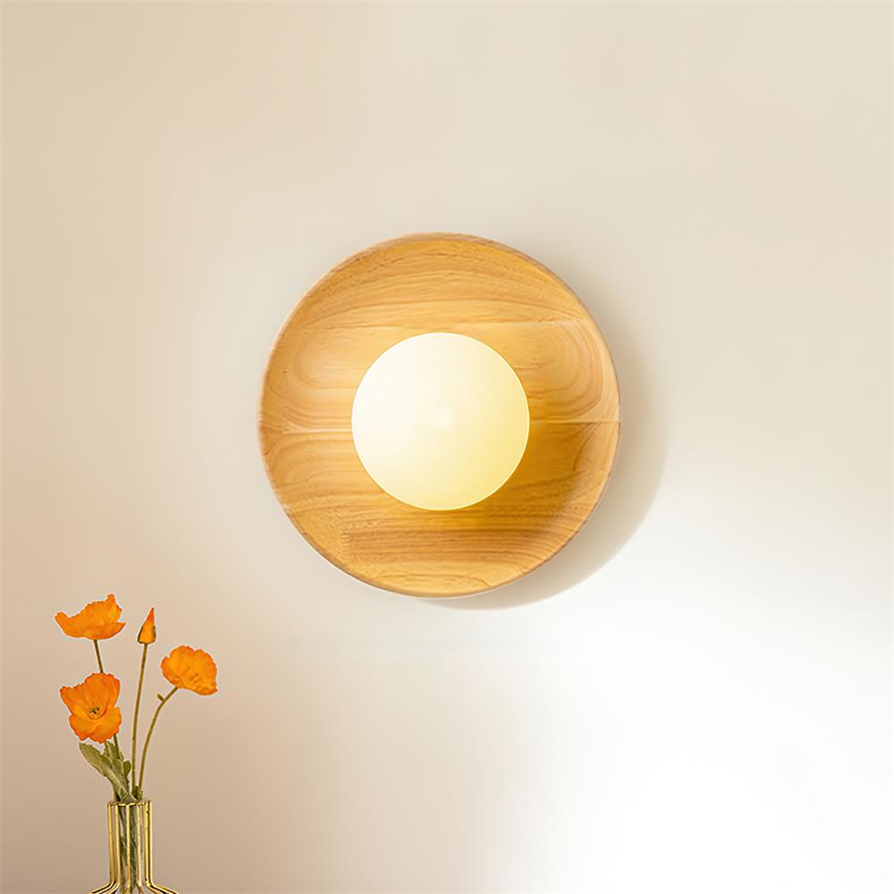 Light oak wooden wall sconce mounted on residential interior wall with warm white glow and decorative flowers
