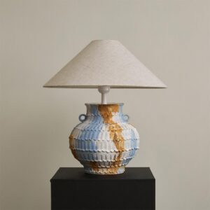 Grazie ceramic table lamp with textured hand-thrown pottery base in blue-beige tones paired with natural linen cone shade on display - modern artisanal table lighting