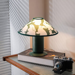 Green table lamp displayed on vintage side table with books and camera in retro-styled bedroom setting