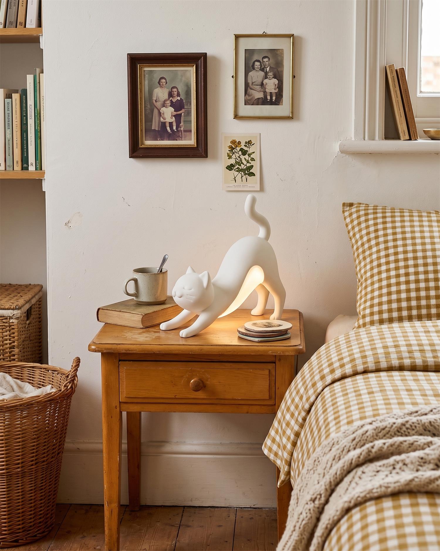 White cat table lamp on bedroom nightstand creating cozy warm lighting atmosphere