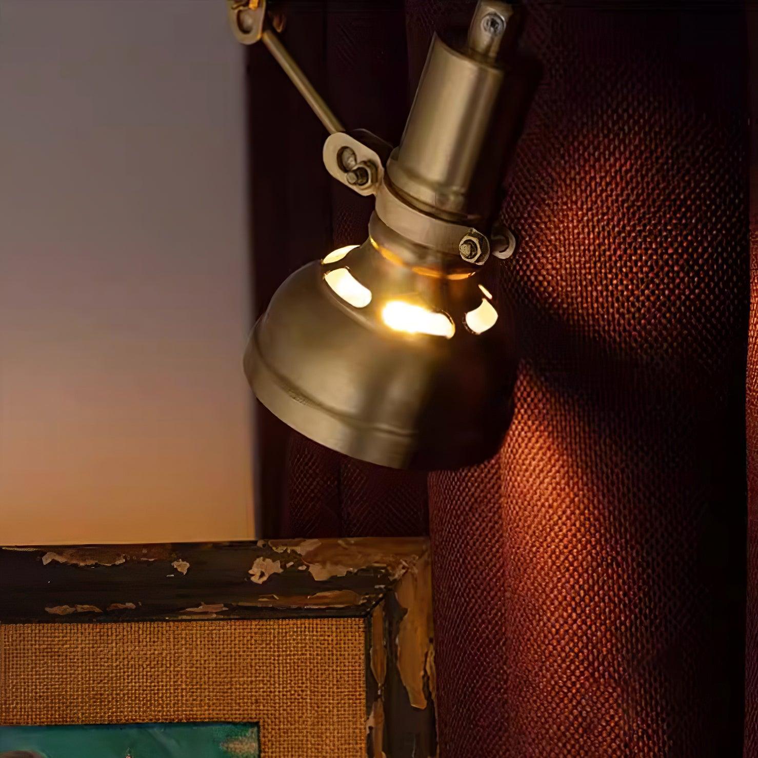 Kane brass wall sconce illuminated showing vented shade design in dim indoor setting