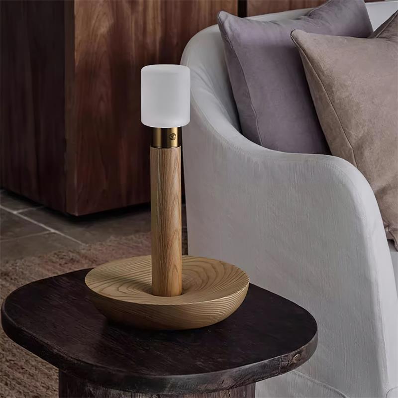 Natural oak wood finish table lamp on living room side table next to fabric sofa warm ambient lighting