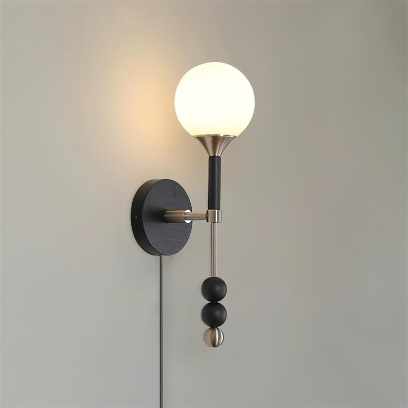 Lolli nickel and black wall sconce with frosted glass orb and metal stem sculptural fixture