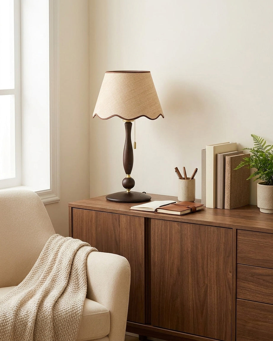 Console table lamp with walnut finish wood base on dark wood cabinet with books, stationery and potted plant styling