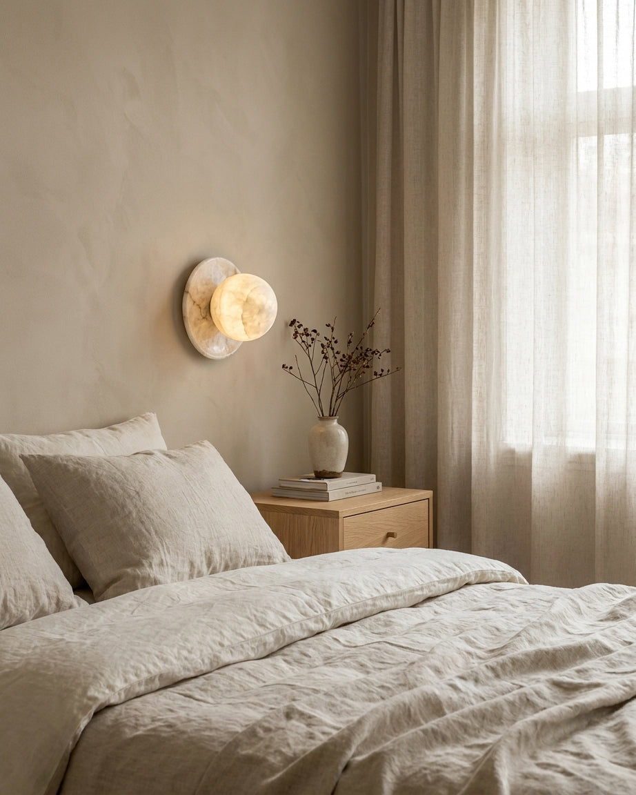 Mia Ball Sconce mounted above bedroom nightstand with neutral linen bedding, warm soft glow for bedroom ambiance