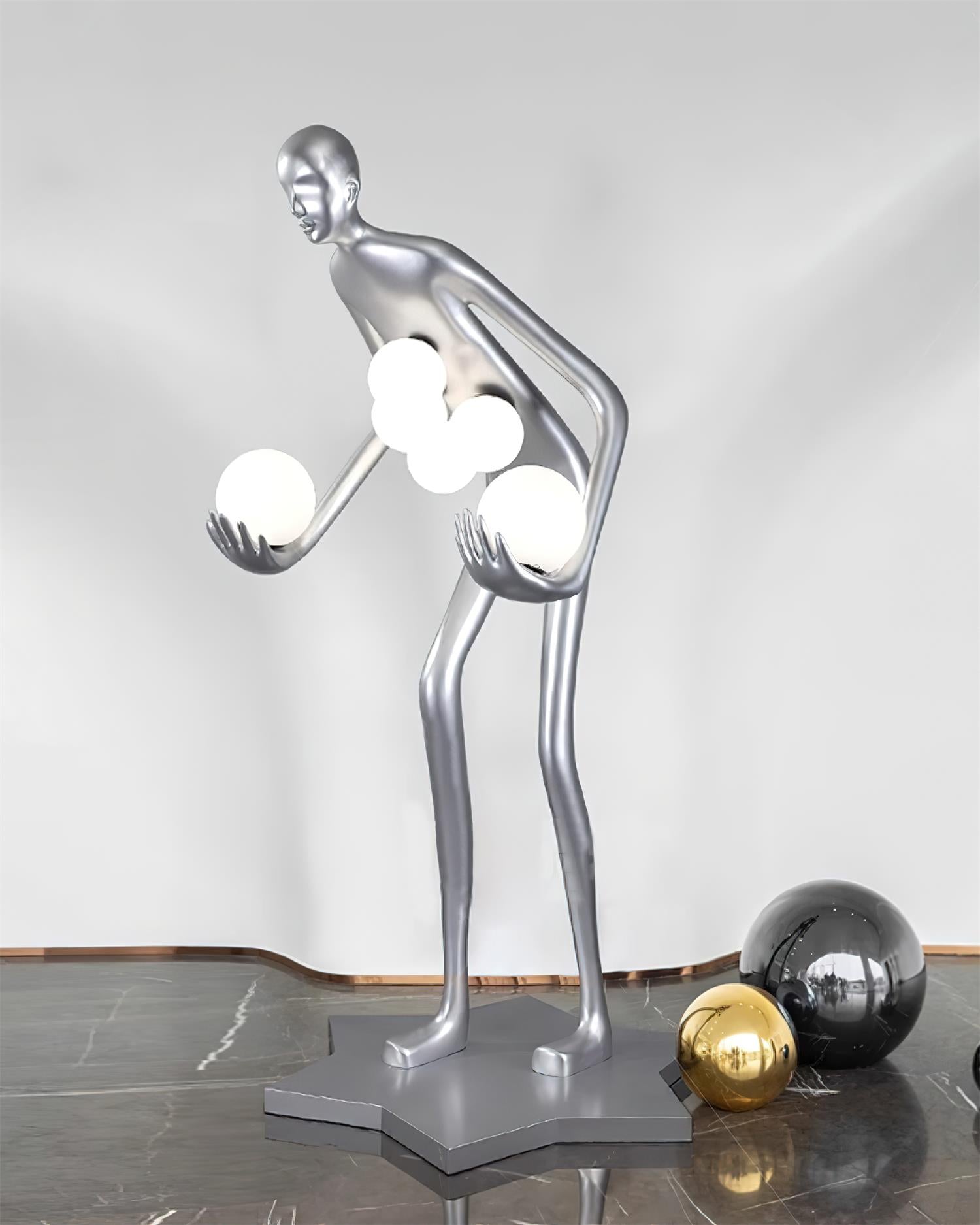 Milly humanoid sculpture floor lamp with bright frosted glass orbs on silver metallic form in polished marble lobby