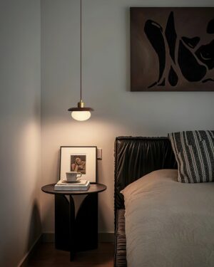 Modern pendant lamp hanging in master bedroom corner creating warm ambient lighting over nightstand