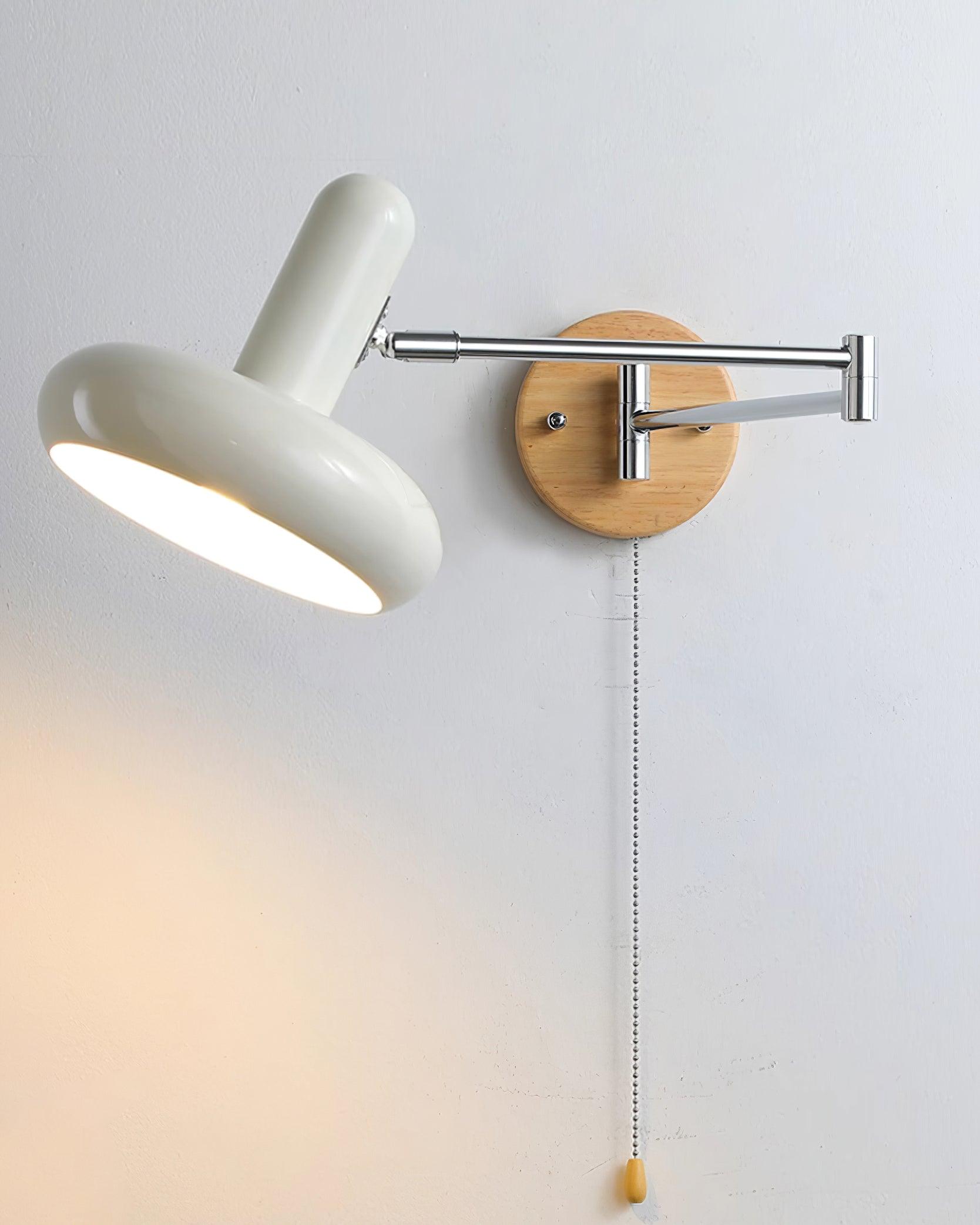 Maddie wall sconce with illuminated milk-white shade creating warm ambient glow, three-quarter view showing sculptural trumpet shade design