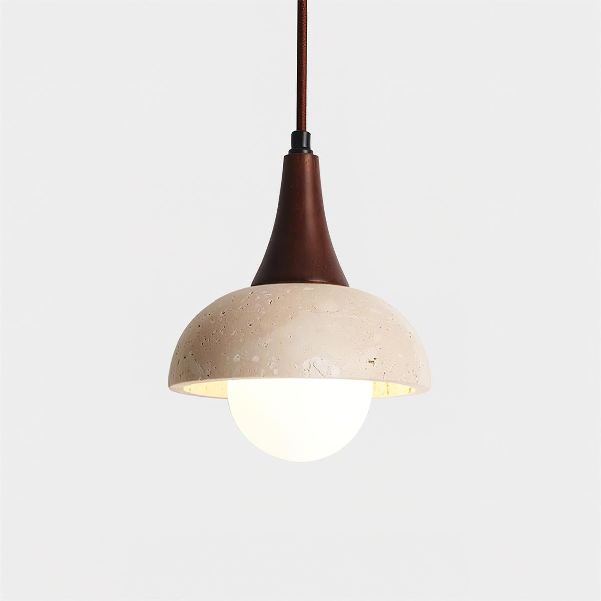 Close-up front view of natural stone travertine dome pendant shade with exposed warm G9 bulb and textured surface