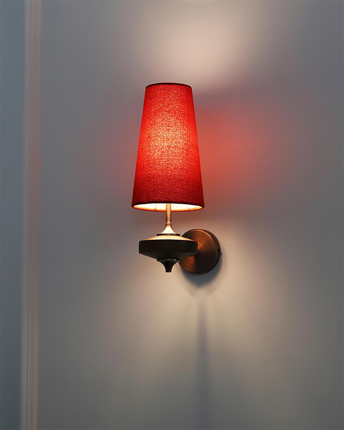 Montera modern wall sconce with red conical shade mounted on neutral wall, showing mounting bracket and installation