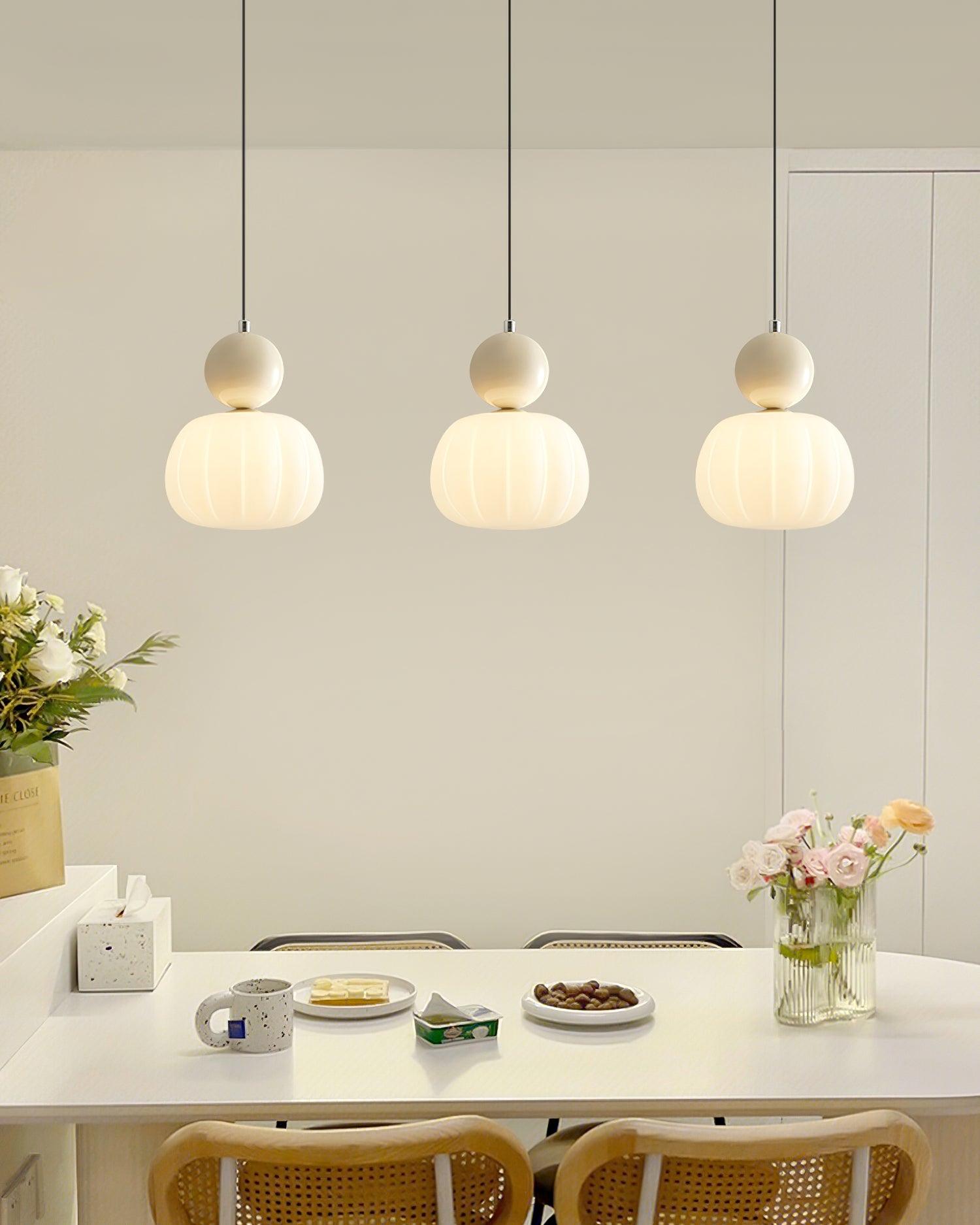Trio of Morris ribbed pendant lights with cream-colored shades in dining room - contemporary dining table lighting