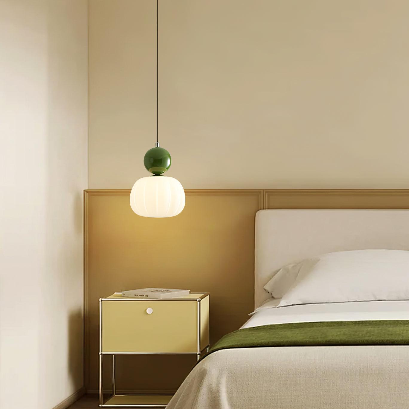 Modern pendant light in green finish installed above bedside table in contemporary bedroom - eye-level interior view