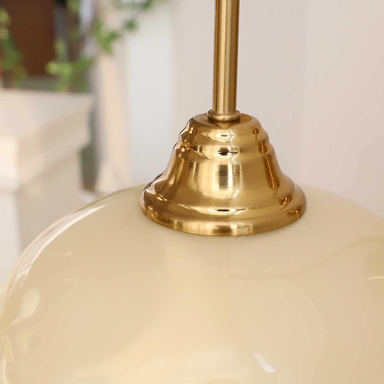 Mid-century modern plug-in wall light with gold brass base and soft ribbed glass shade, styling detail in contemporary interior