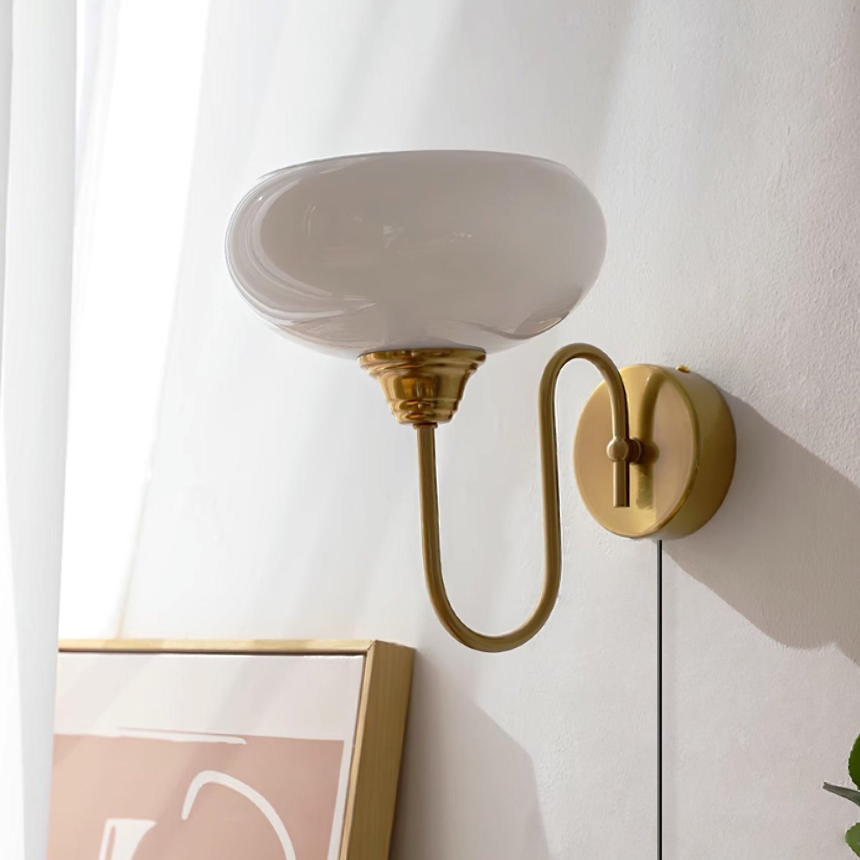 Plug-in wall sconce with textured milk glass in white finish, dimmed warm light creating cozy ambiance in bedroom setting