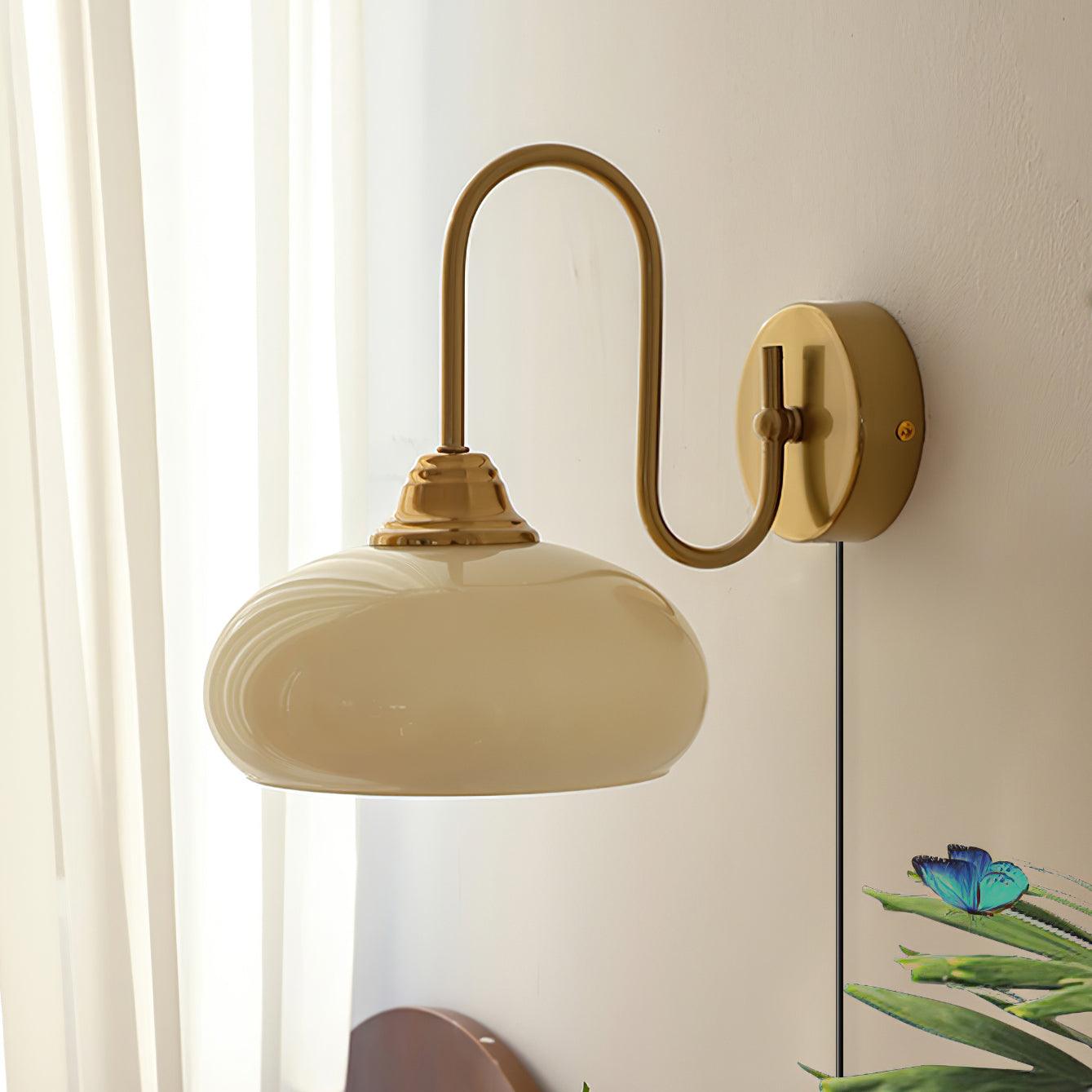 Damp-rated textile glass plug-in wall sconce in beige finish with frosted glass shade, close-up detail showing glass texture and metal base