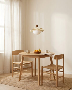 Ondelle pendant light suspended above wooden round dining table in warm dining room setting