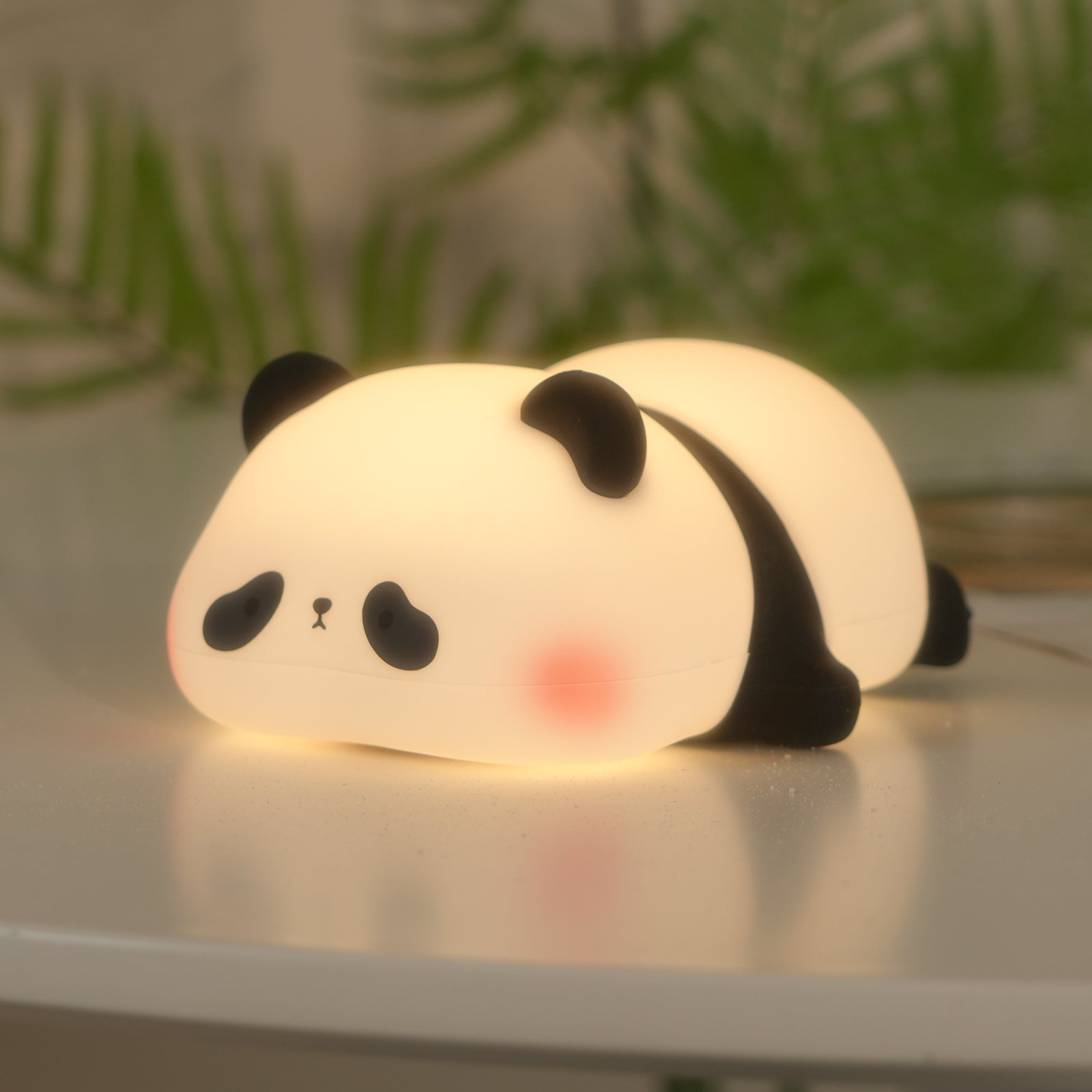 Panda night light overhead view on white surface with green foliage - smooth matte finish