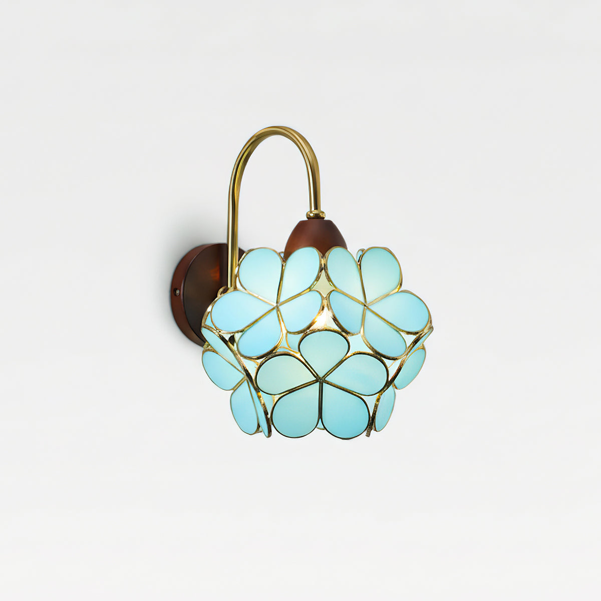 Petalora wall sconce casting warm botanical shadows in home office workspace