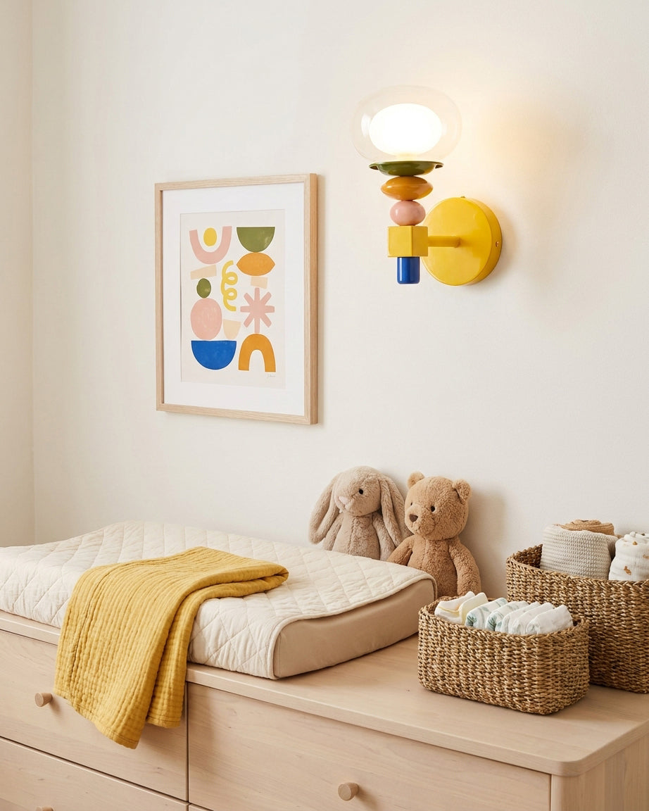 Popella wall sconce mounted in modern nursery above wooden changing table with warm ambient light