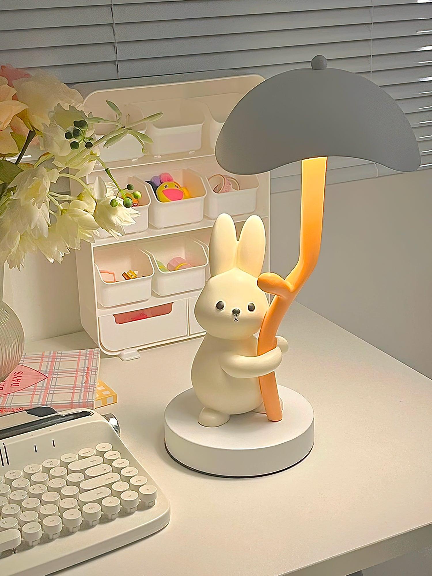 Rabbit hug table lamp with gray lampshade on home workspace desk with keyboard