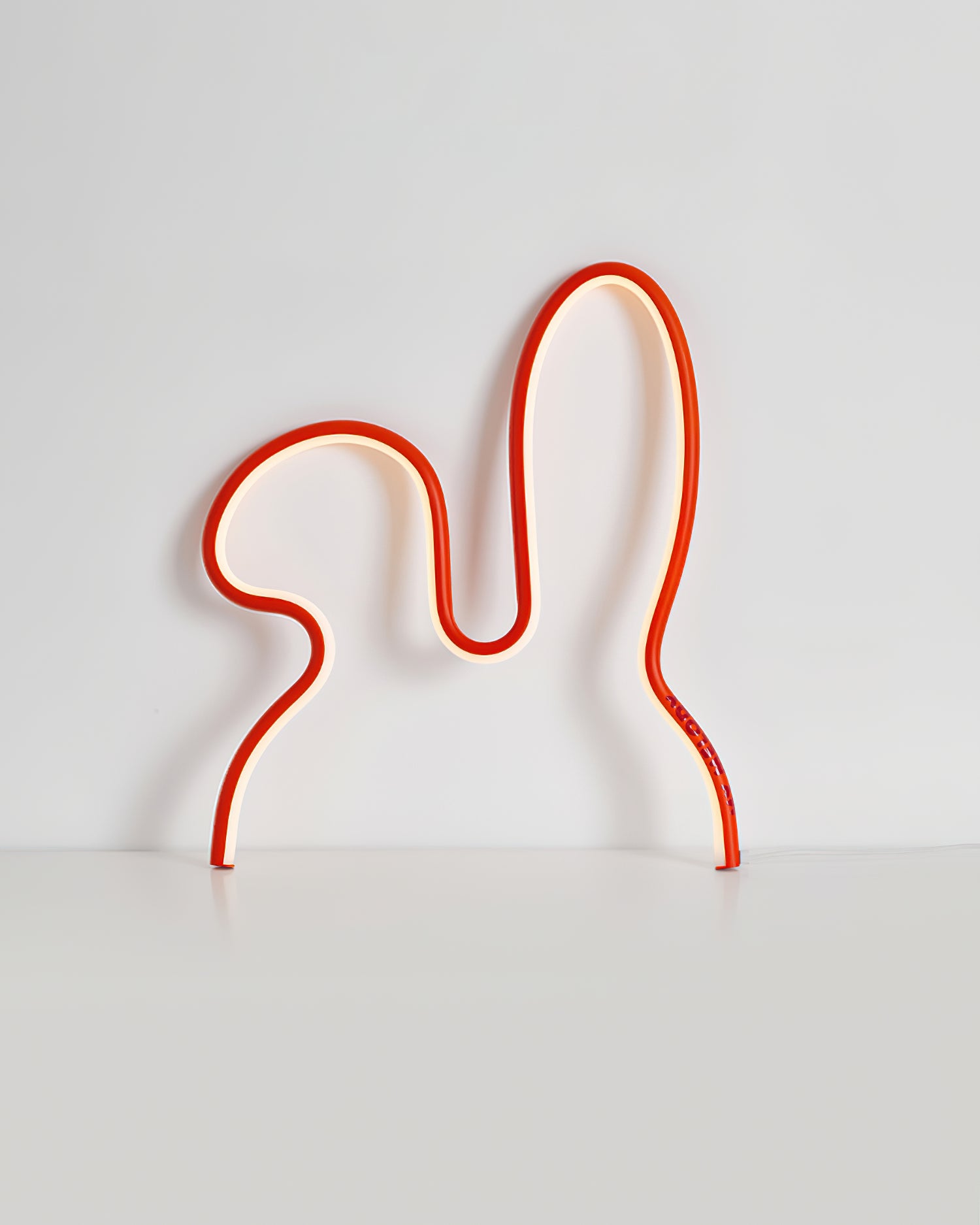 Compact small red rabbit neon lamp front view on light gray studio background