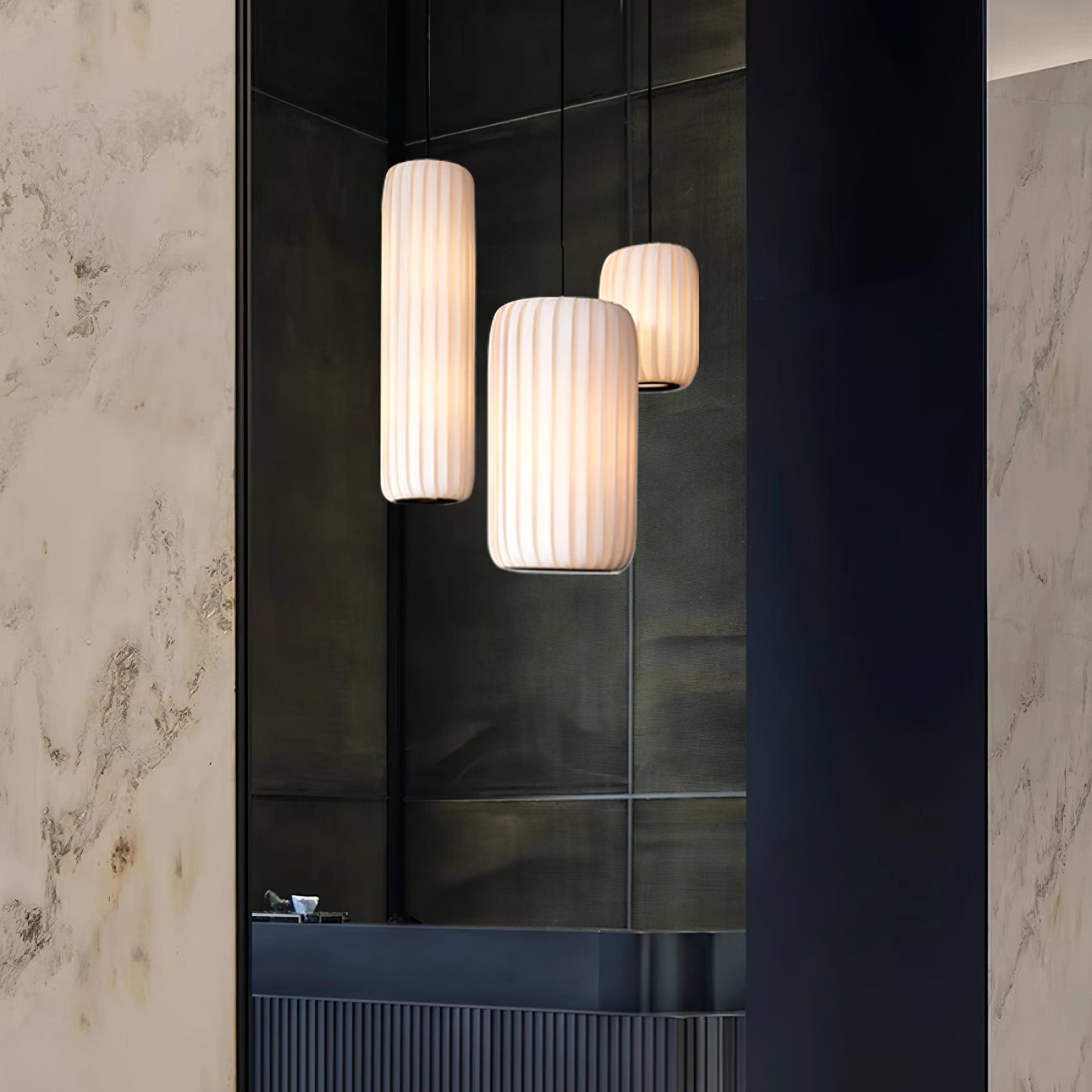 Rossau pendant light creating warm ambient glow in modern hallway with dark marble walls