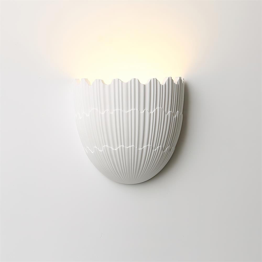 Side profile of white ceramic shell wall sconce with fluted ridge details
