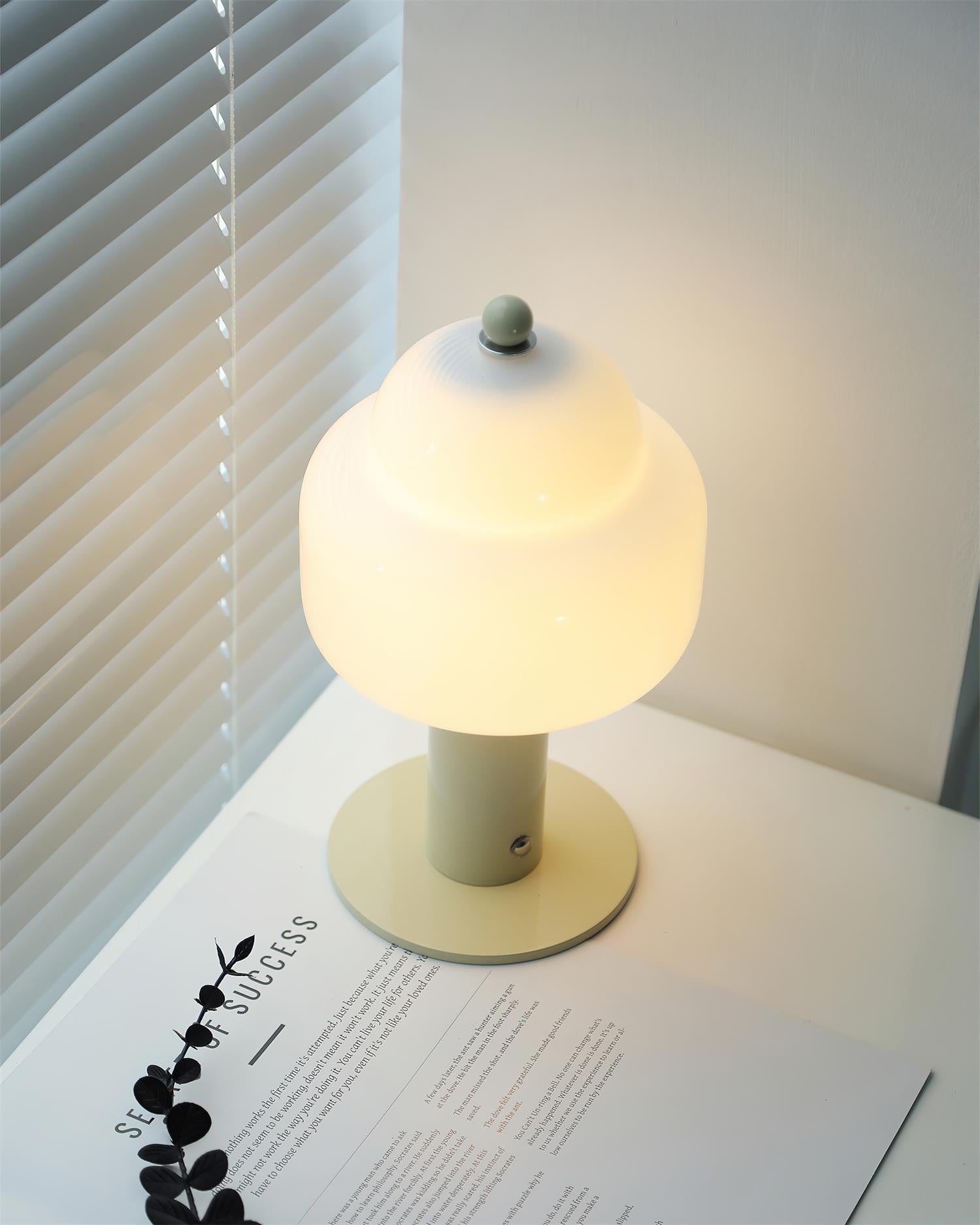 Soreli beige table lamp with frosted glass shade and green finial on home office desk