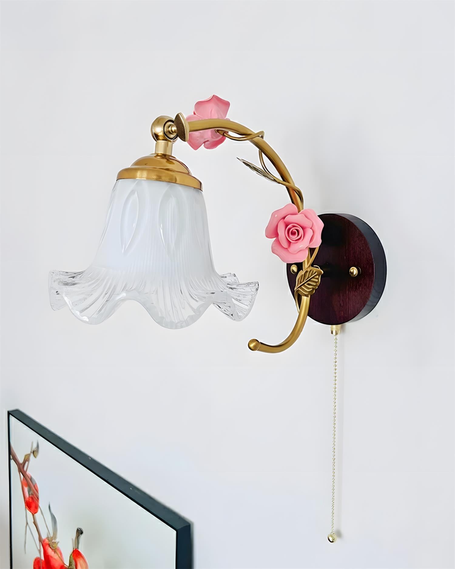 Botanical-inspired wall sconce detail showing rose ornaments and curved metal stem artistry