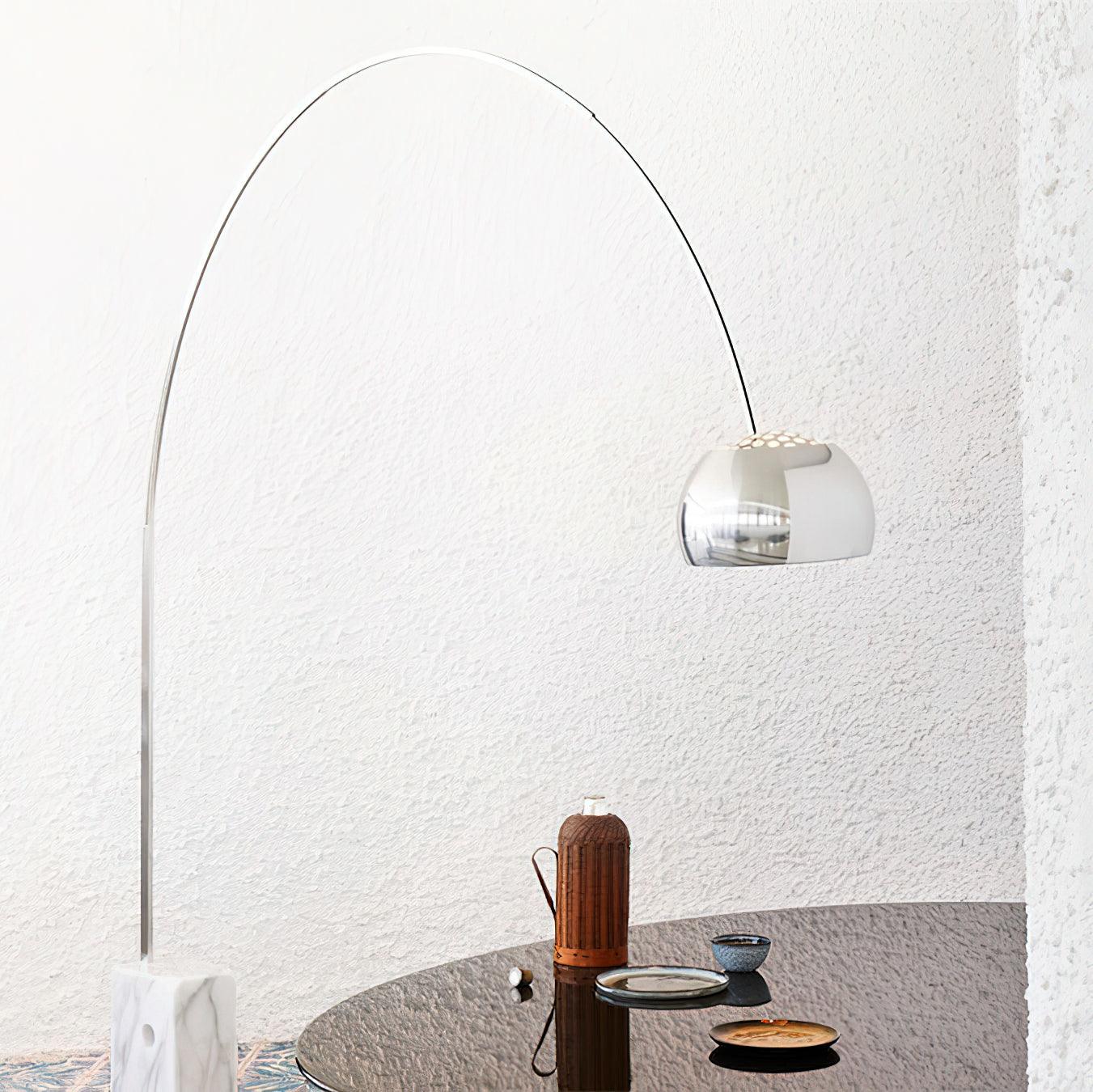 Arc floor lamp with translucent white dome shade and silver metal arc in minimalist tea room