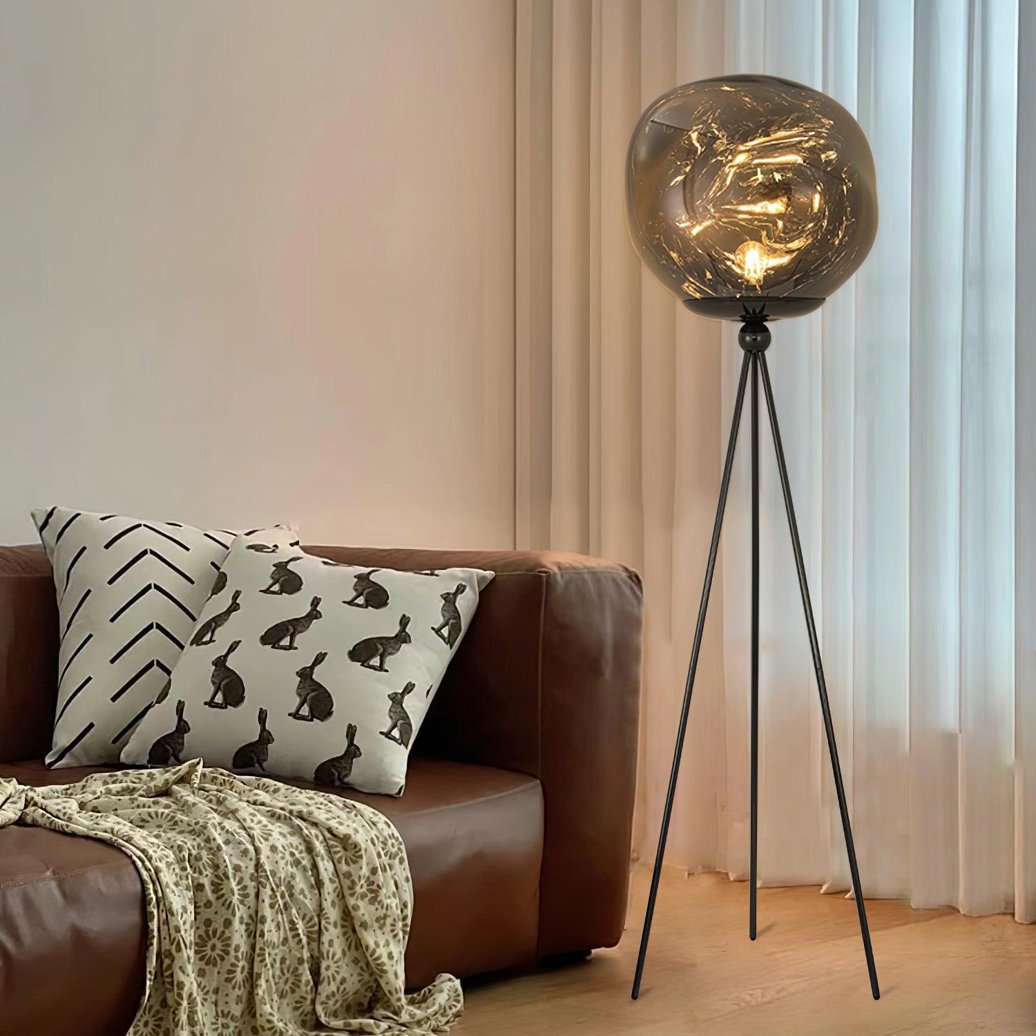 Contemporary tripod floor lamp in gold finish with artistic molten lava glass creating unique light effect