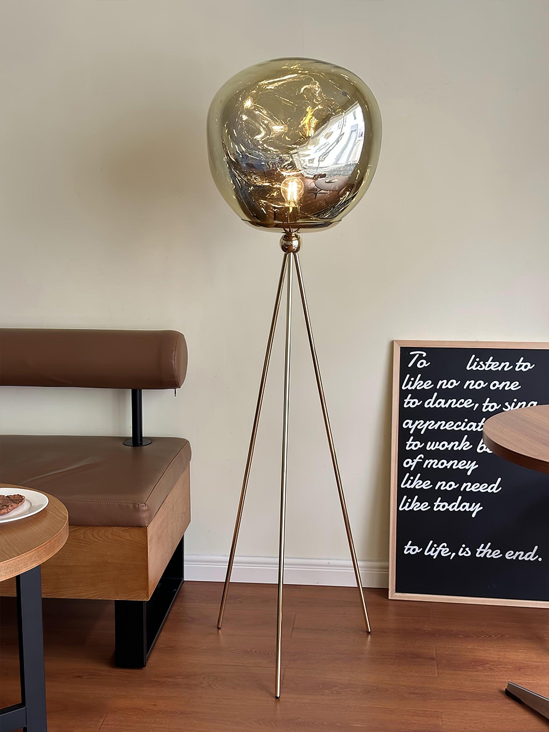 Modern tripod floor lamp with rose gold frame and decorative molten glass shade accent piece