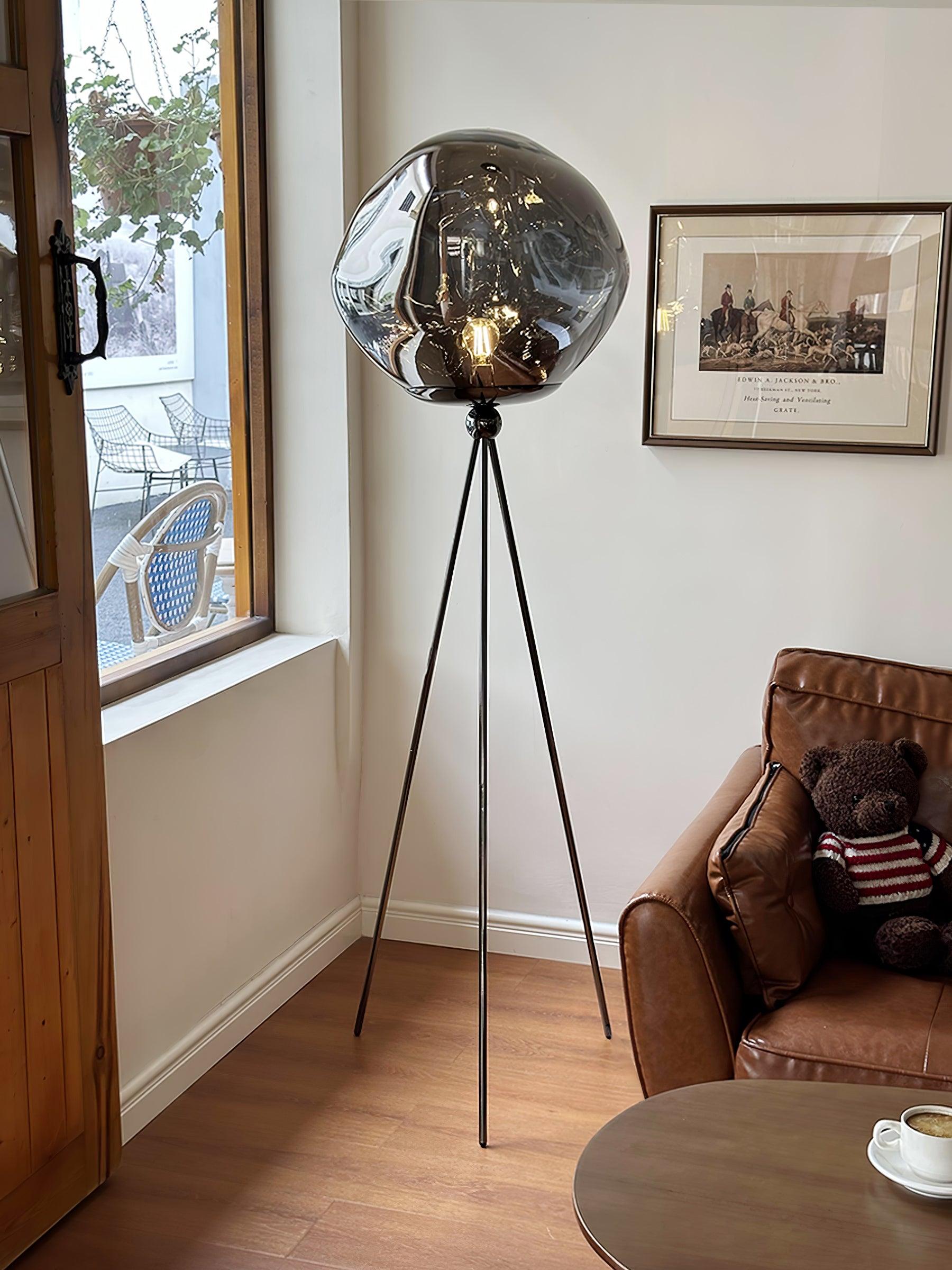 Contemporary tripod floor lamp showcasing handcrafted molten lava glass and sophisticated design aesthetic