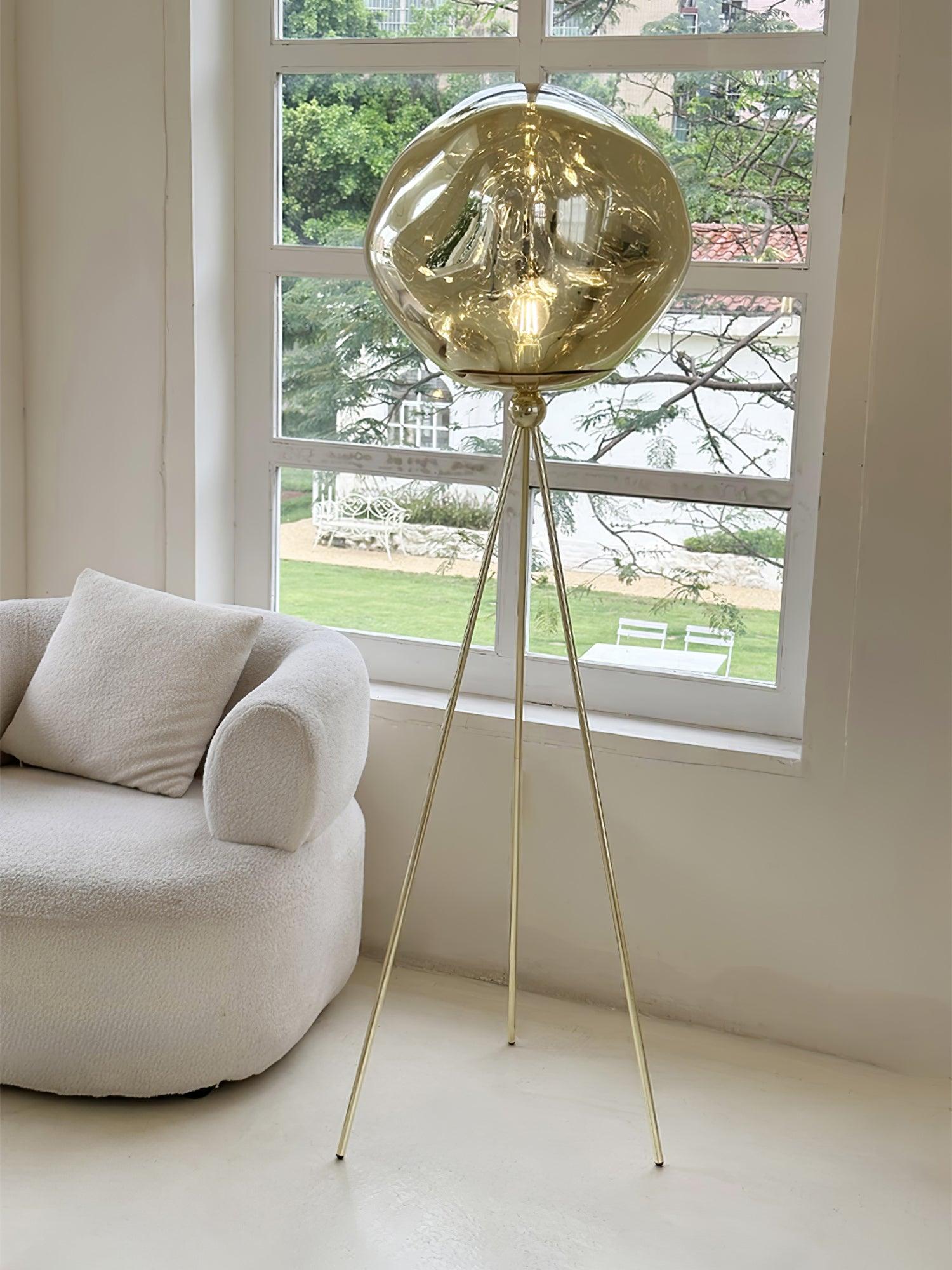Modern black tripod floor lamp with unique molten glass shade in contemporary home decor application