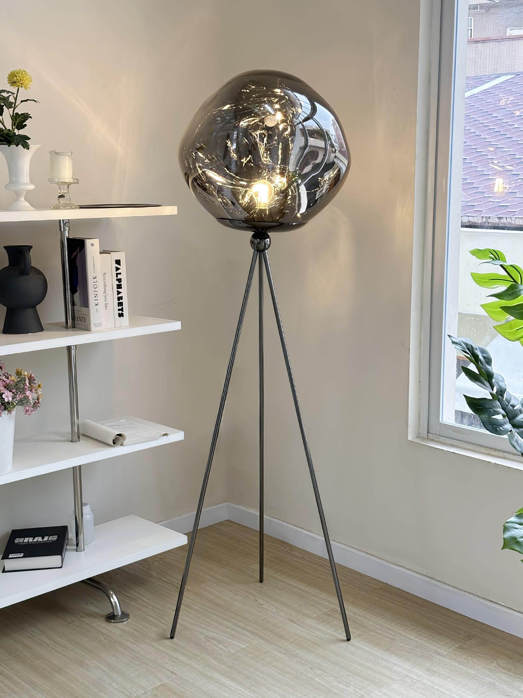 Contemporary tripod floor lamp with smoked molten glass shade and sleek black metal tripod construction