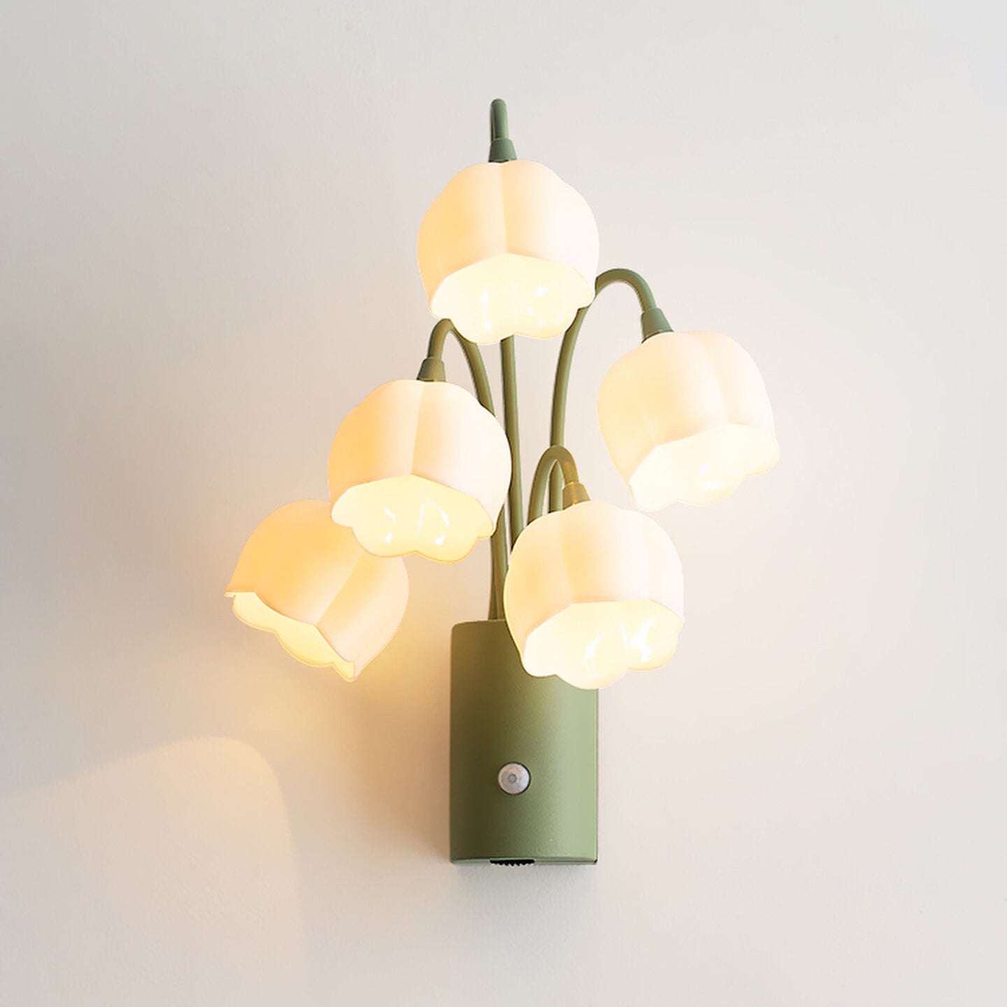 Kids nursery room with gentle warm-glowing frosted flower wall sconce providing safe motion-activated night light